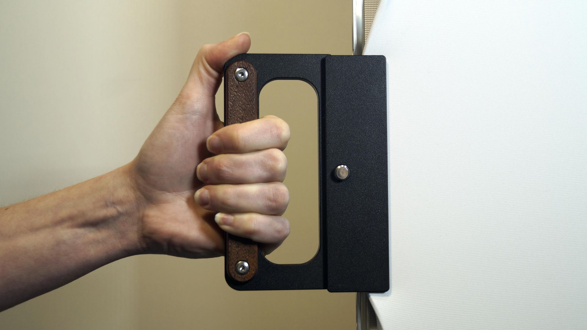 Eine Person hält einen schwarzen Griff mit Holzgriff.