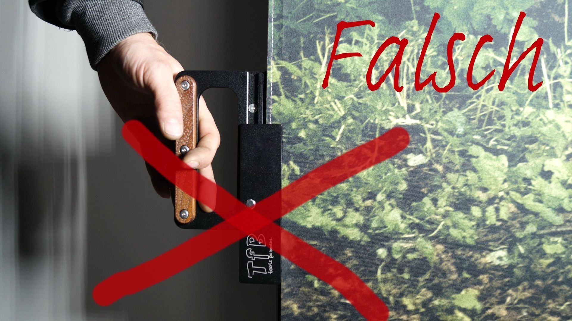 Eine Person hält eine Türklinke mit einem roten Kreuz und der Aufschrift „Falsch“ darauf