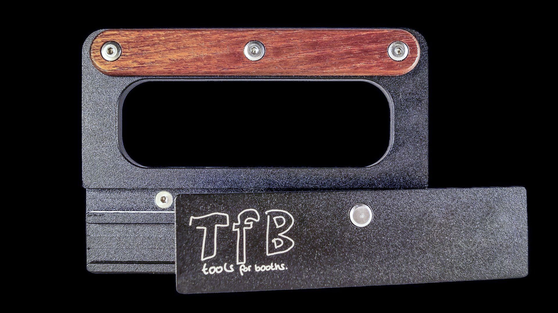 Ein schwarzer Gegenstand mit einem Holzgriff und dem Wort „tfb“ darauf.