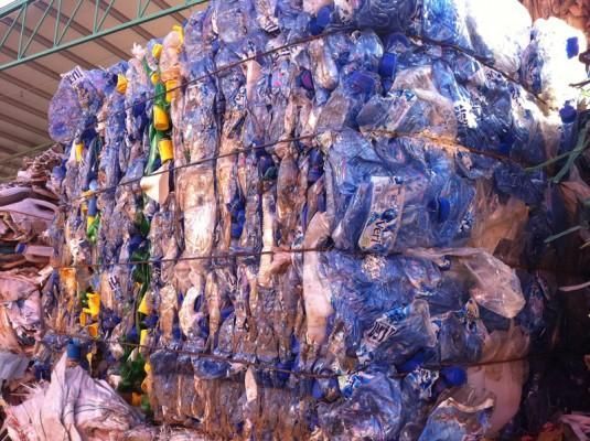 Una gran pila de botellas de plástico apiladas una encima de otra.
