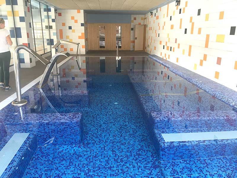 Una gran piscina cubierta con azulejos azules