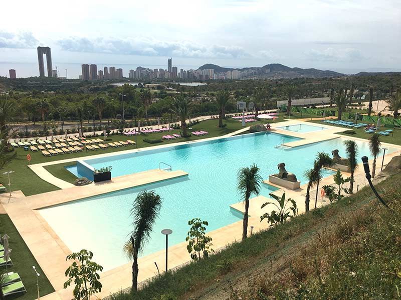 Una vista aérea de una gran piscina con una ciudad al fondo.