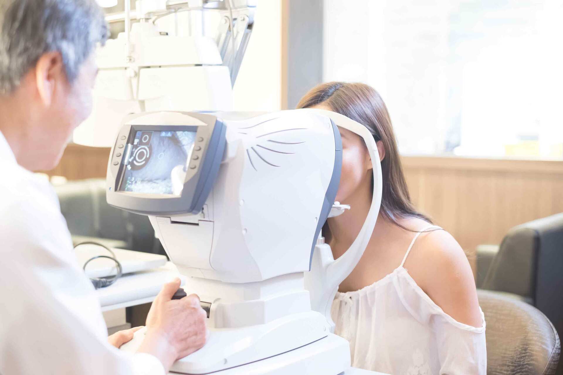 Un opticien mesurant l'œil avec un autorefractomètre