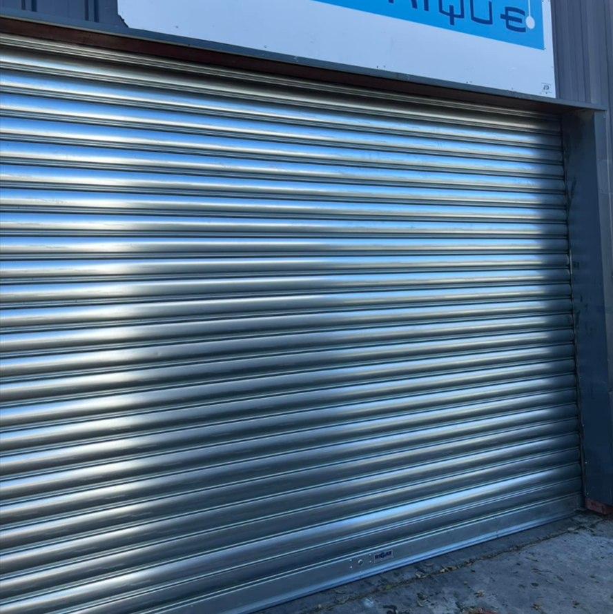 Volet roulant métallique argenté fermé sur une entrée de magasin