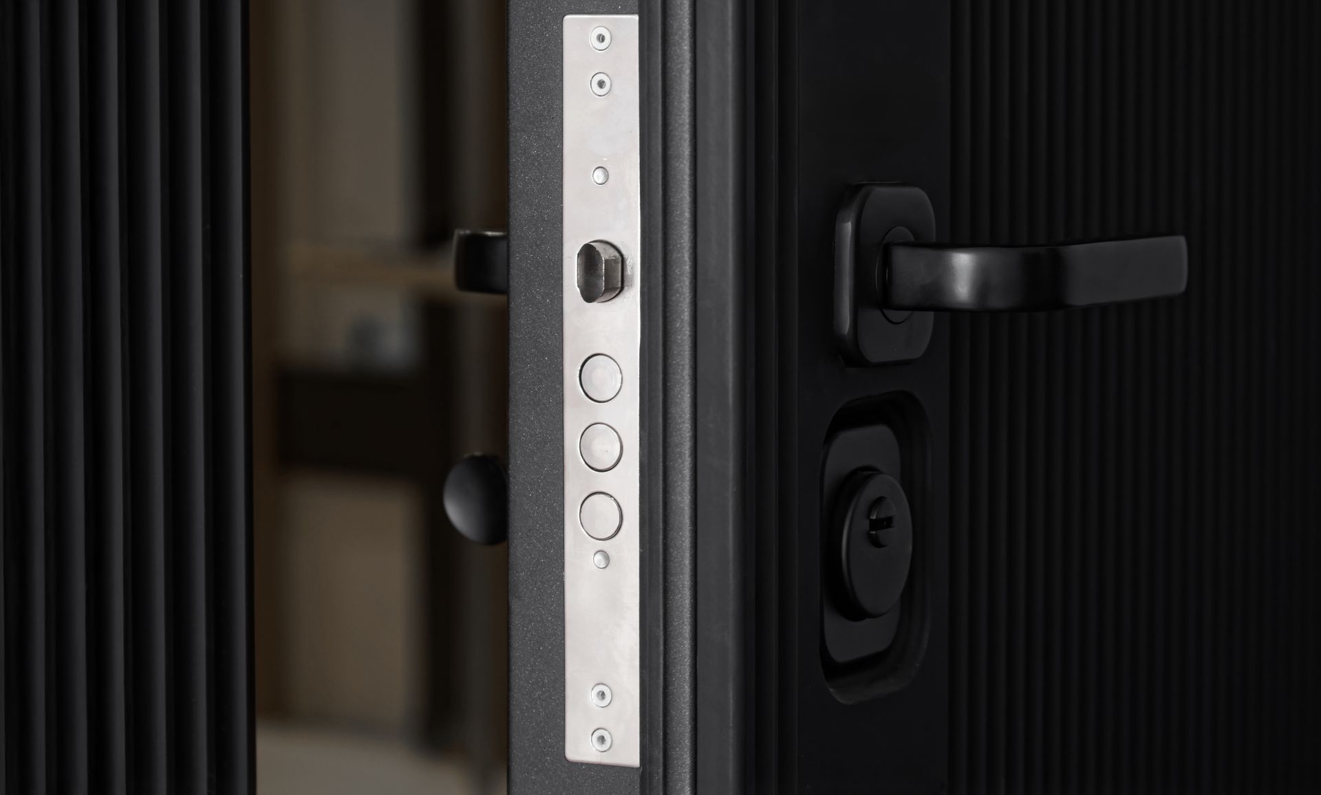 Gros plan sur une serrure de porte moderne noire et un loquet argenté sur un cadre de porte en verre