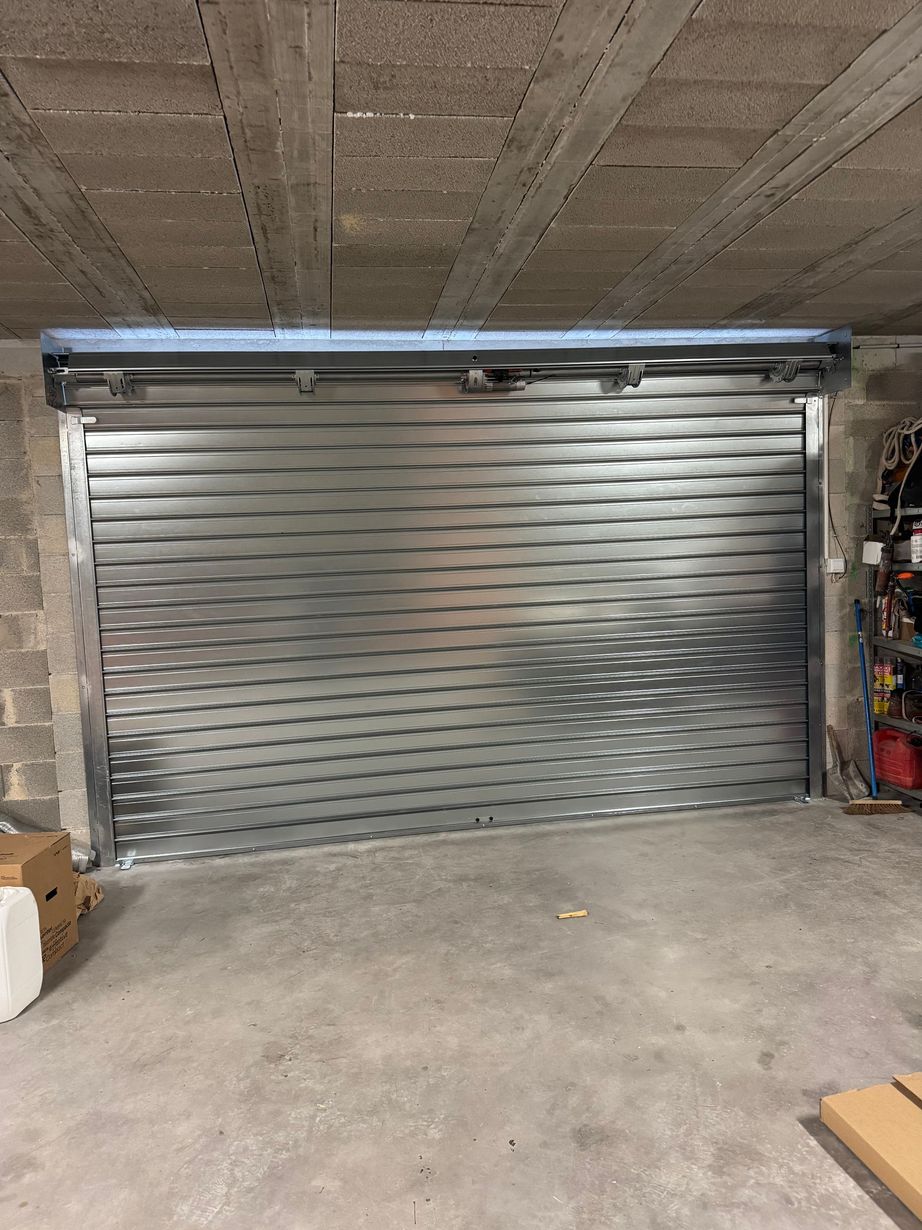 Porte de garage métallique argentée fermée dans un parking intérieur en béton