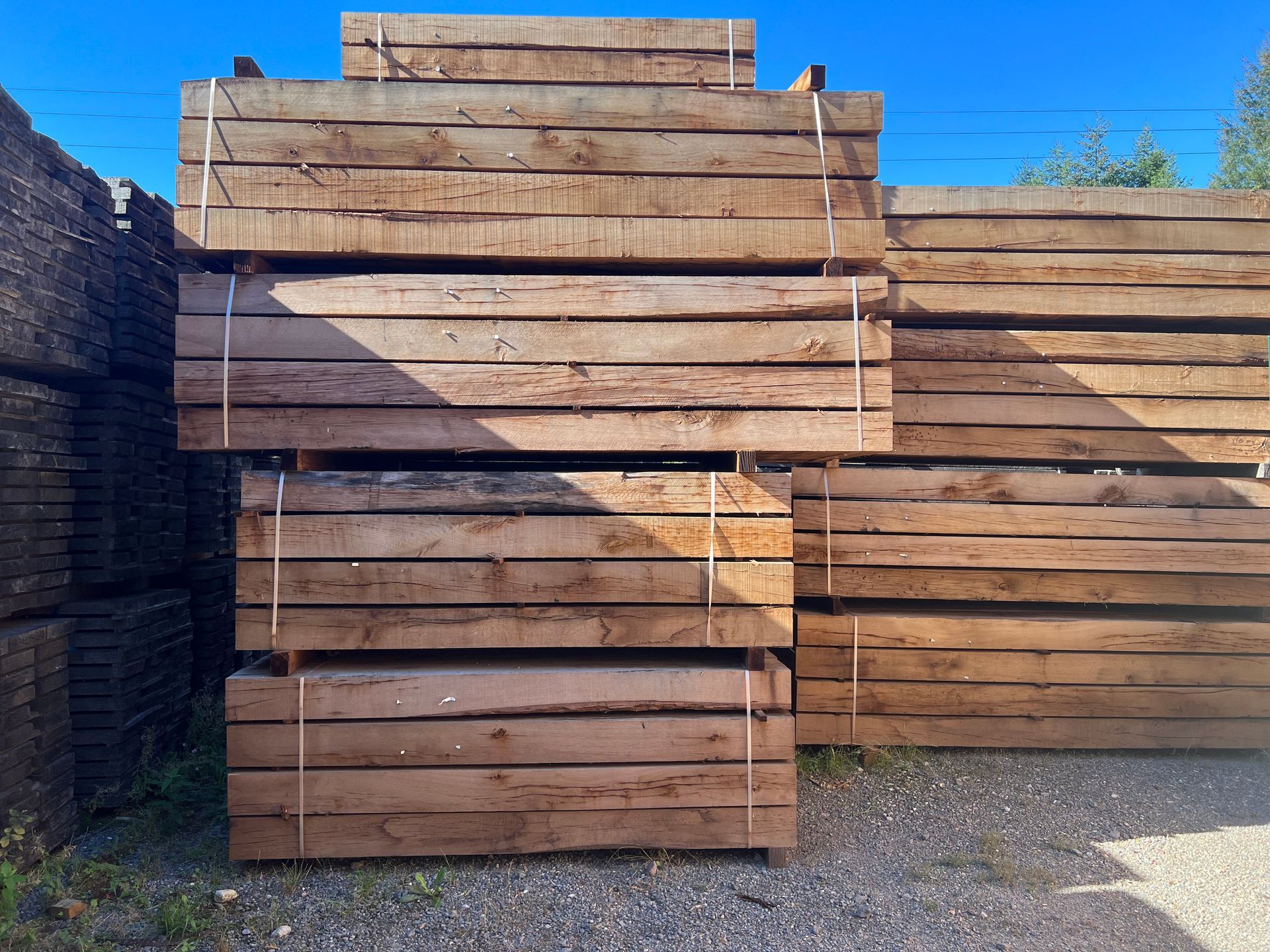 Des planches de bois empilées sur le sol d'un atelier.