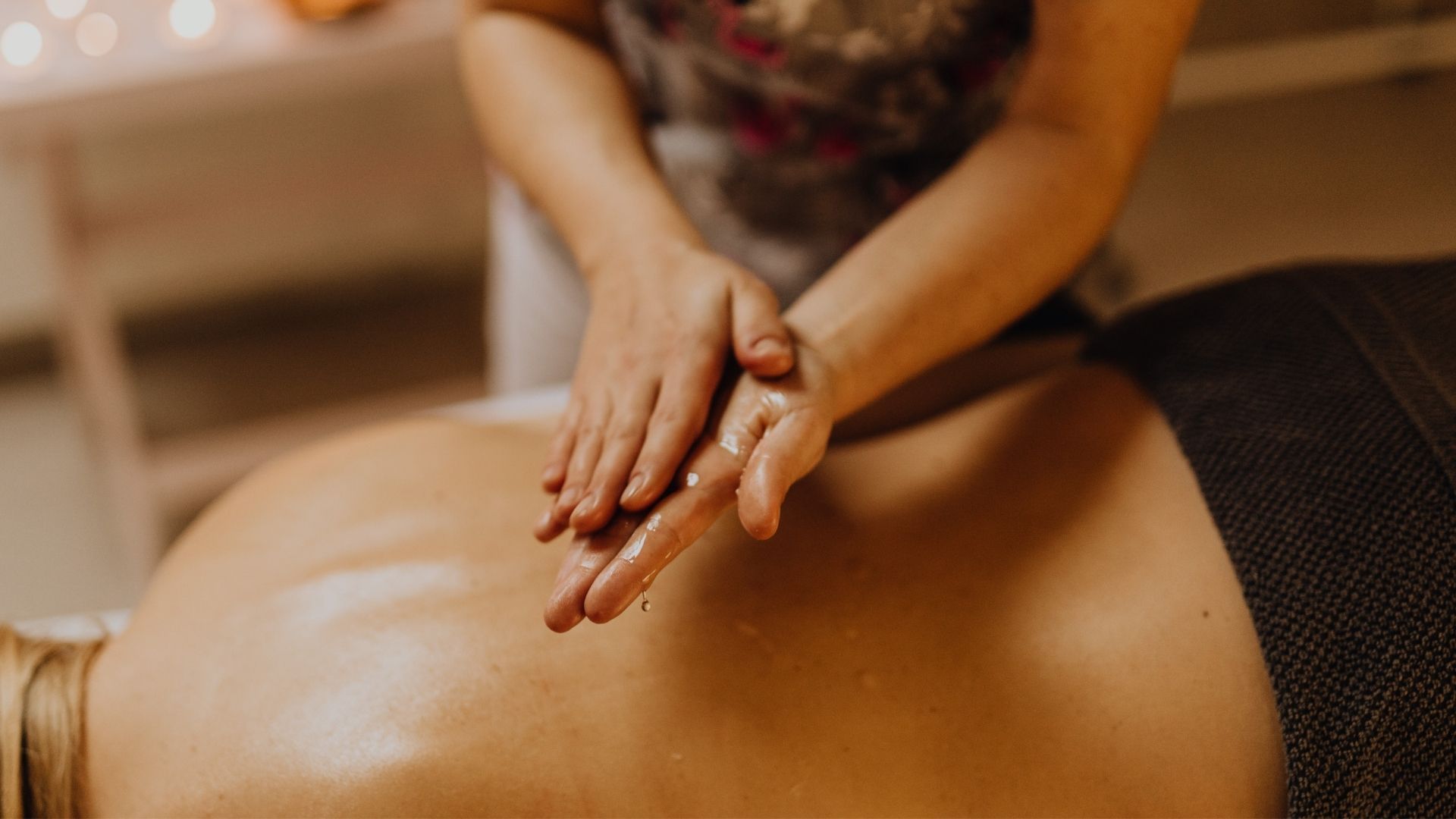 Manos dando masaje de espalda con aceite.