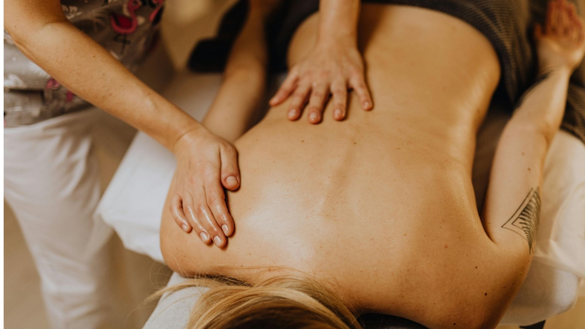 Manos masajeando la espalda de una persona durante un masaje.