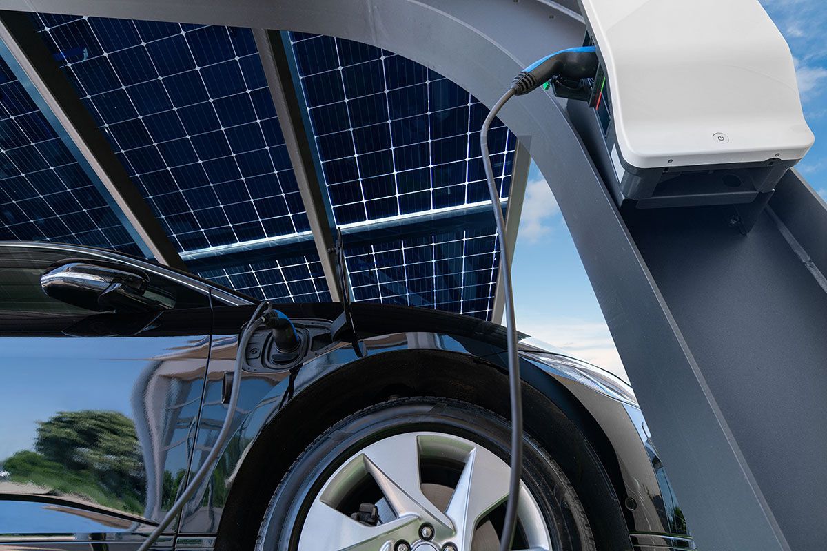 Zoom sur une voiture électrique qui charge sous un carport solaire