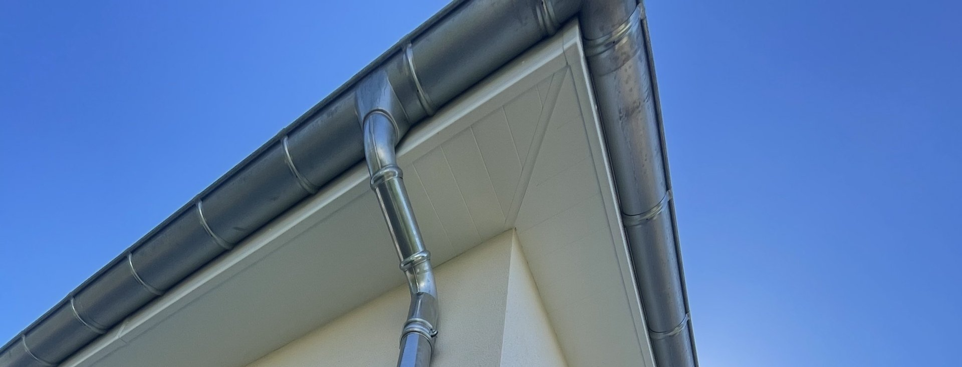 Gouttière en zinc sur une maison blanche