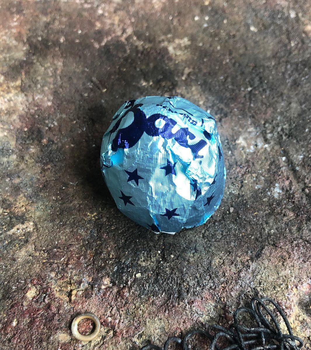 Ein blauer Ball mit Sternen darauf liegt auf einem Felsen