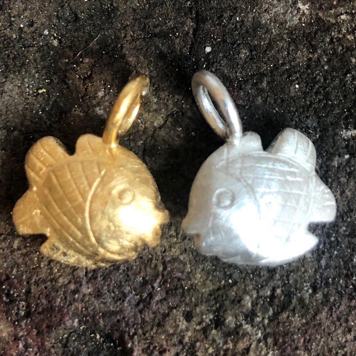 Zwei goldene und silberne fischförmige Anhänger