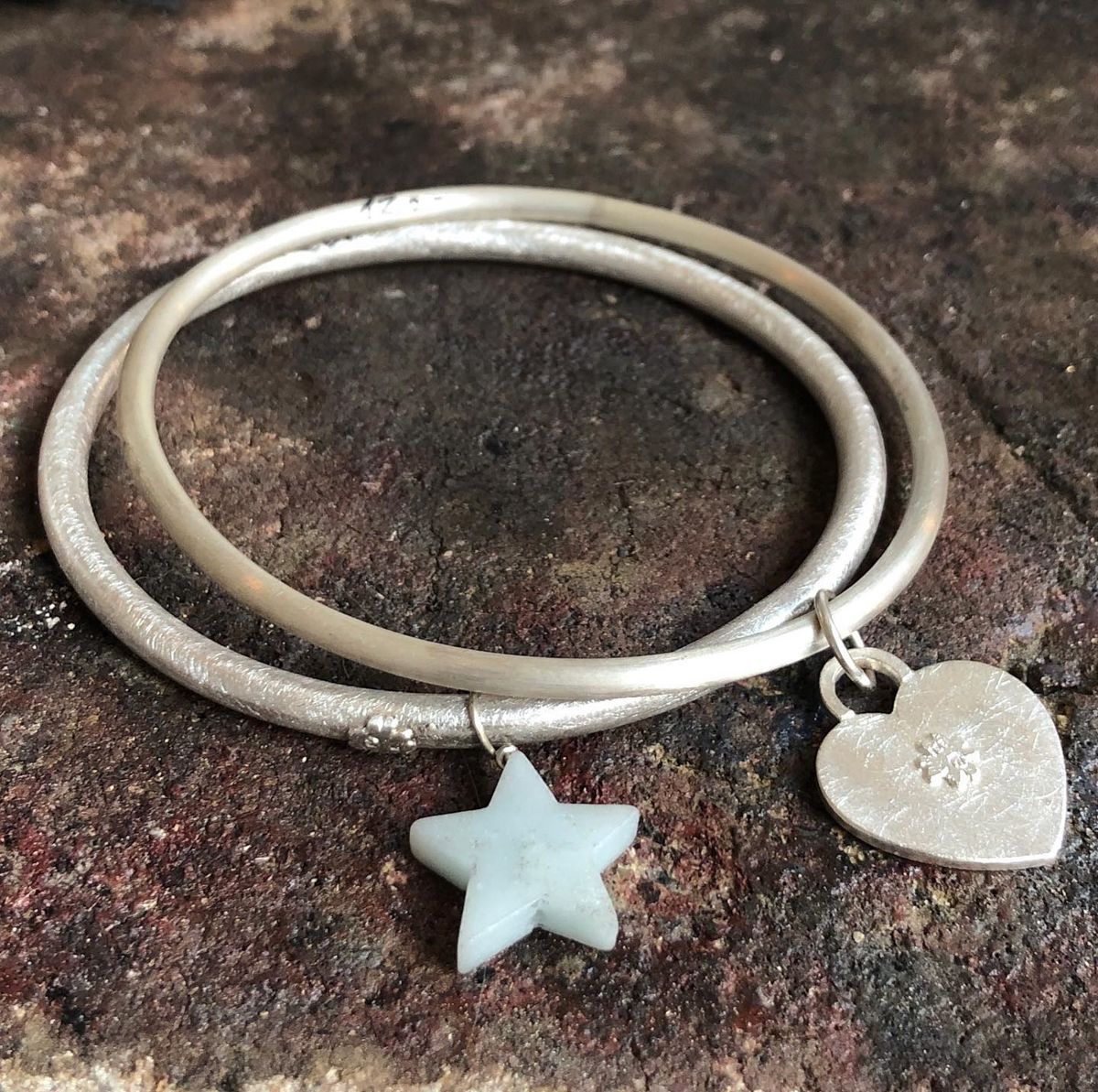 Ein silbernes Armband mit einem Stern und einem Herzanhänger