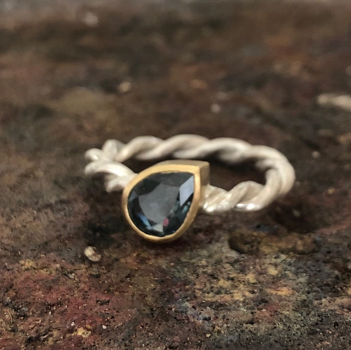 Ein Silber- und Goldring mit einem schwarzen Stein in der Mitte