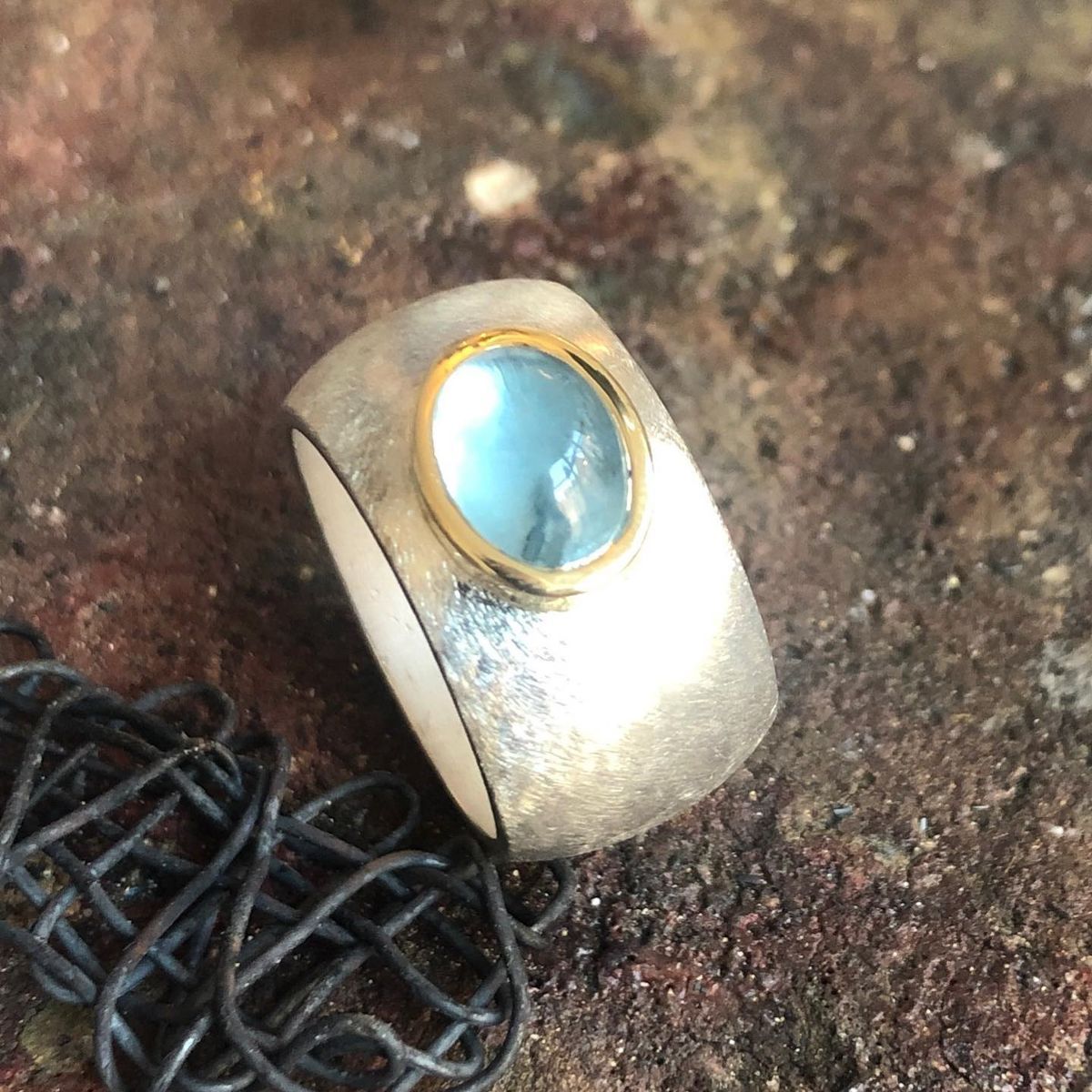Ein silberner Ring mit einem blauen Stein in der Mitte