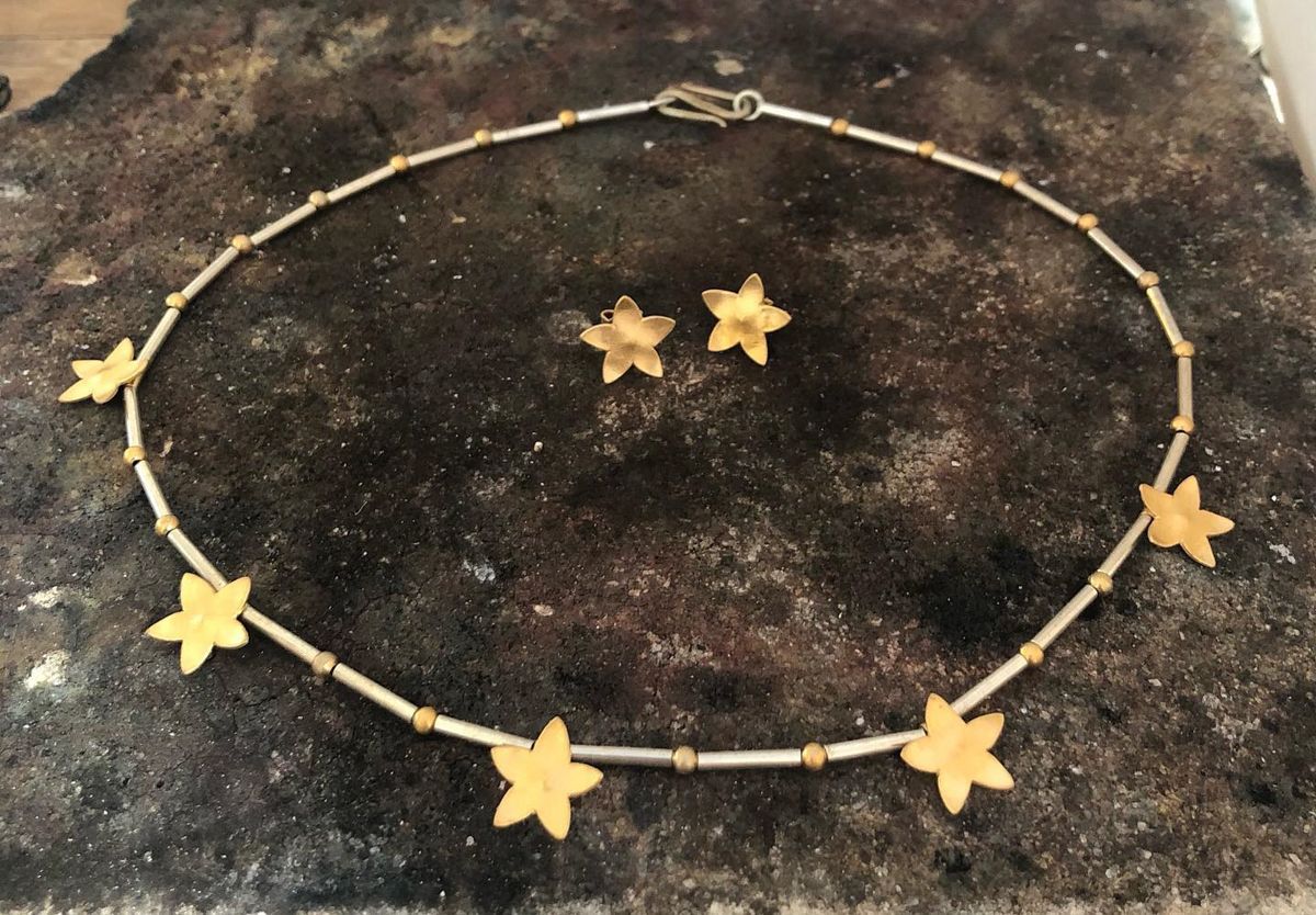 Ein Set aus Halskette und Ohrringen mit goldenen Sternen auf einem Tisch