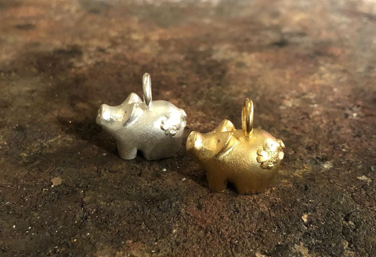 Zwei Kettenanhänger Glücksschweine in Silber und Gold