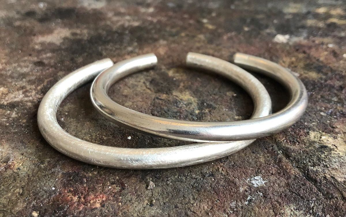 Zwei silberne Armbänder liegen übereinander