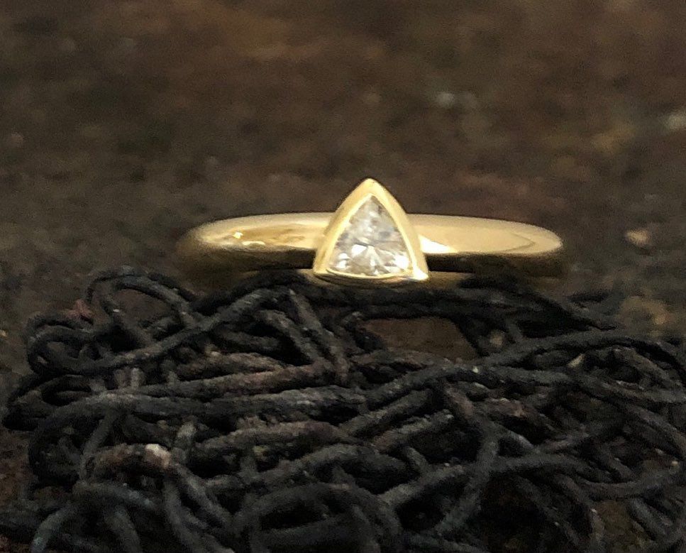 Ein goldener Ring mit einem dreieckigen Diamanten