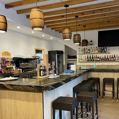 Un bar con barriles de madera colgando del techo.