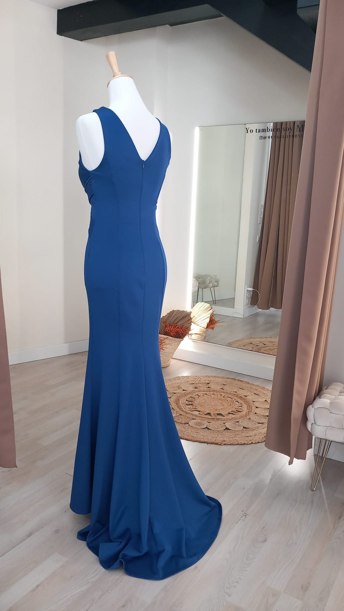 Un vestido azul está sobre un maniquí en una habitación.