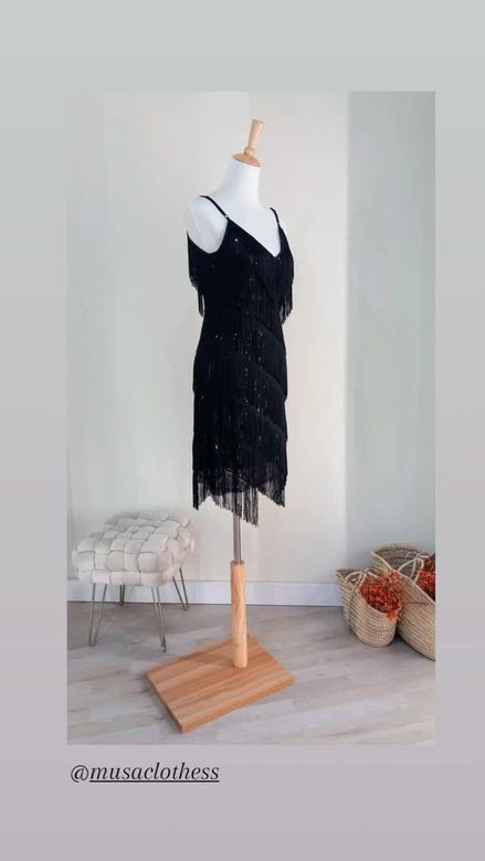 Un vestido negro está sobre un maniquí en una habitación.