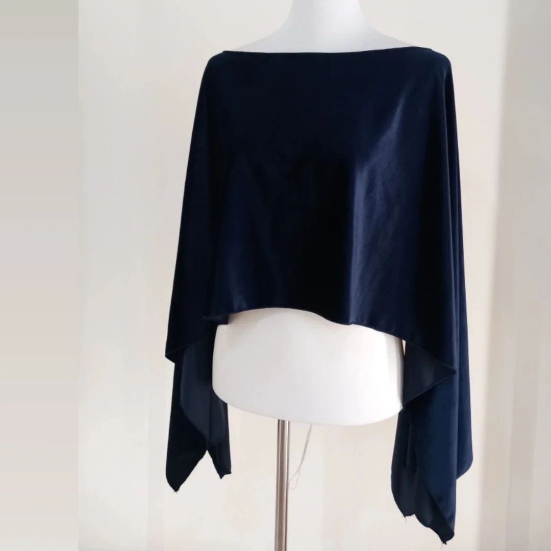 Un poncho azul está sobre un maniquí blanco.