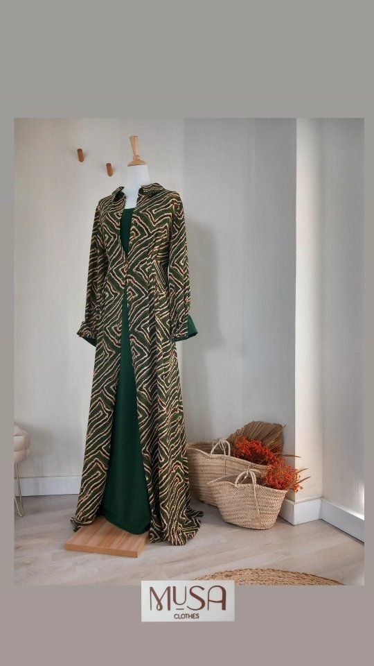Un vestido verde y dorado está sobre un maniquí en una habitación.