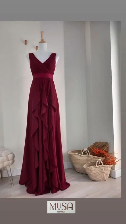Un vestido burdeos está sobre un maniquí en una habitación.
