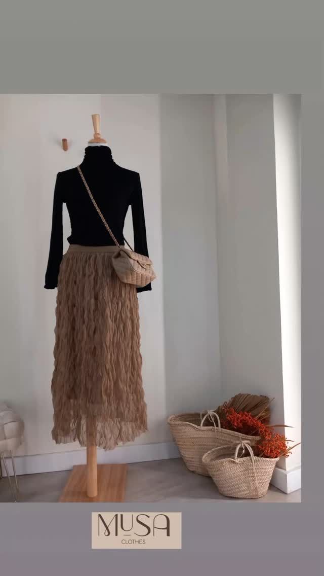 Un maniquí lleva una falda y un top negro.