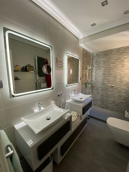 reforma de baño en Madrid, con azulejo blanco, ducha con decorado, muebles de baño de diseño.