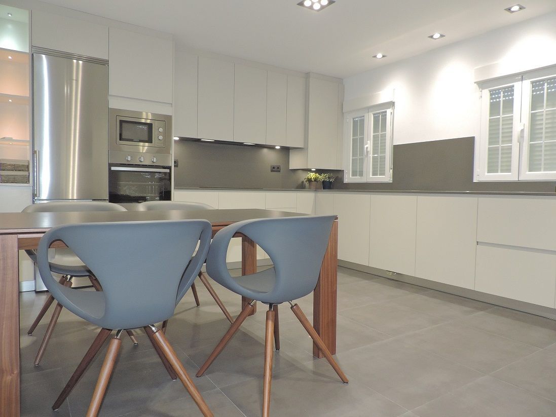 Una cocina con muebles blancos,  electrodomésticos en acero inoxidable, encimera Silestone