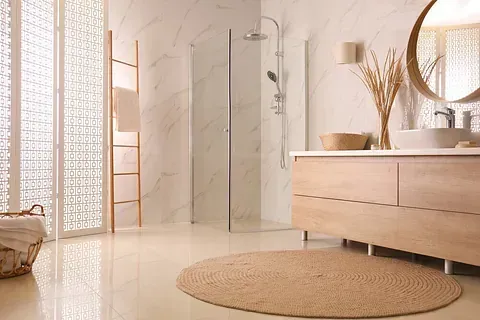 Un baño con ducha, lavabo, espejo y alfombra.