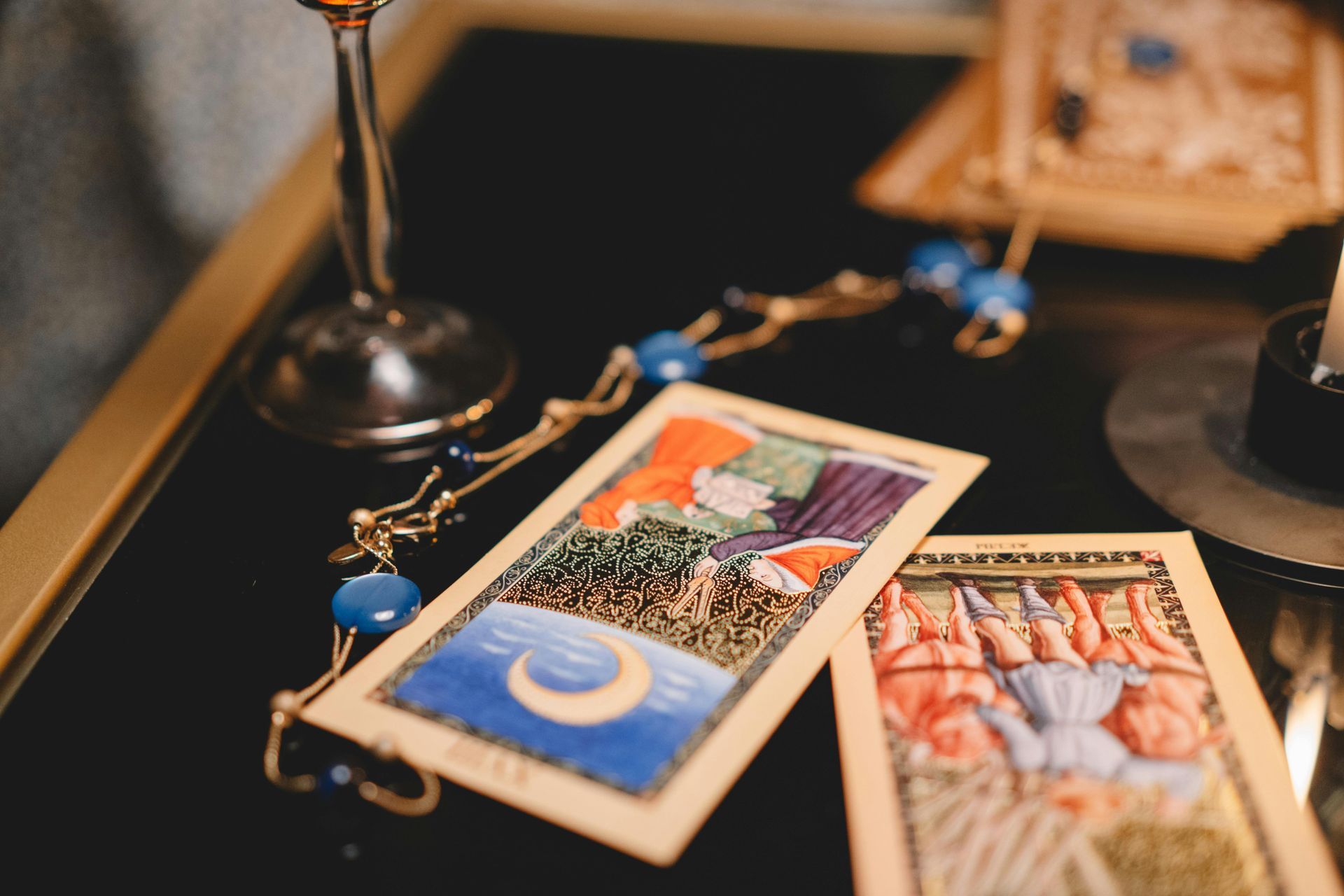 Deux cartes de tarot sont posées sur une table à côté d'une bougie.