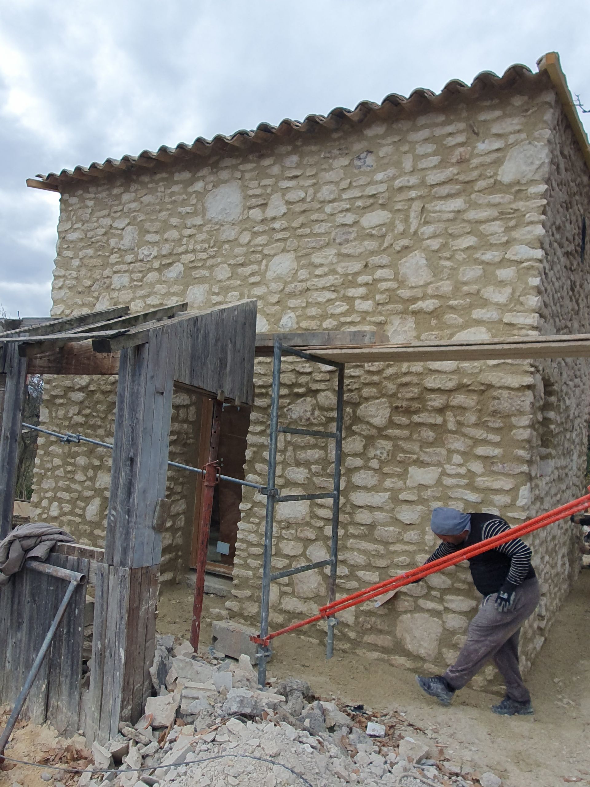 Un artisan devant une vieille bâtisse.
