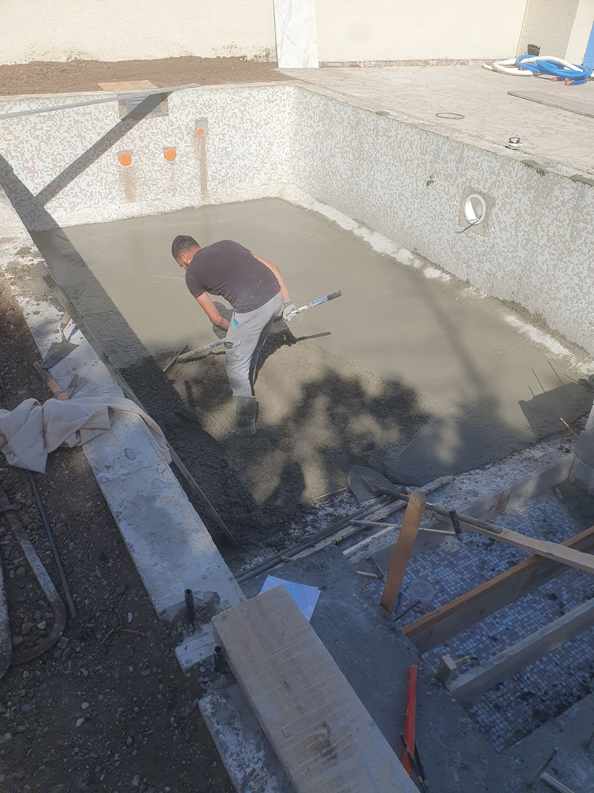 Un artisan dans le trou d'une piscine.