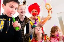 Un grupo de niños está jugando con un payaso en una fiesta.