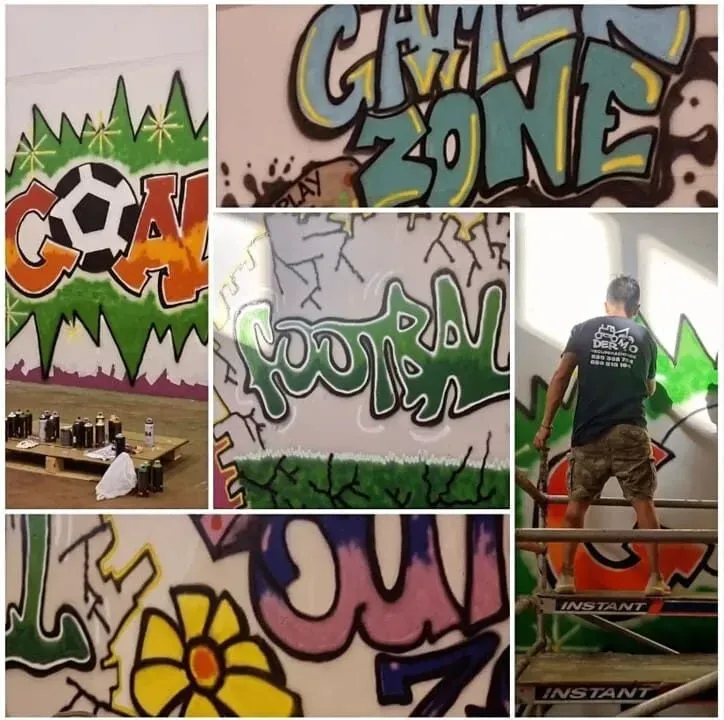 Un hombre está pintando un grafiti en una pared que dice zona de grafitis.