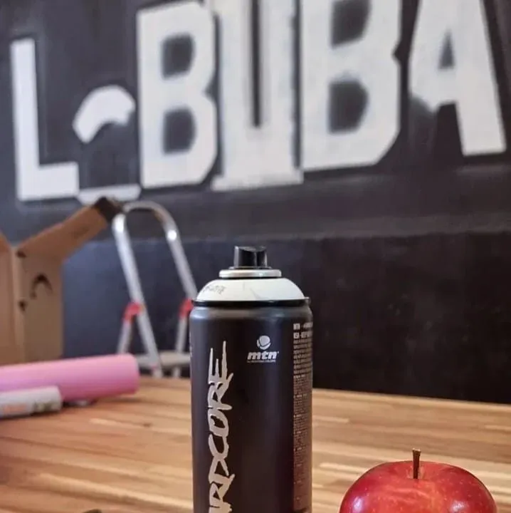 Una lata de pintura en aerosol rdcore reposa sobre una mesa de madera