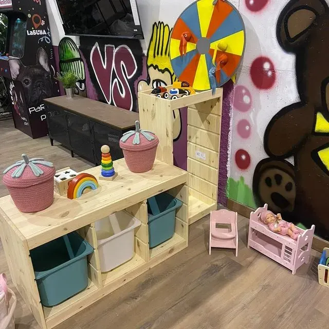 Un estante de madera con juguetes y una rueda que dice vs.