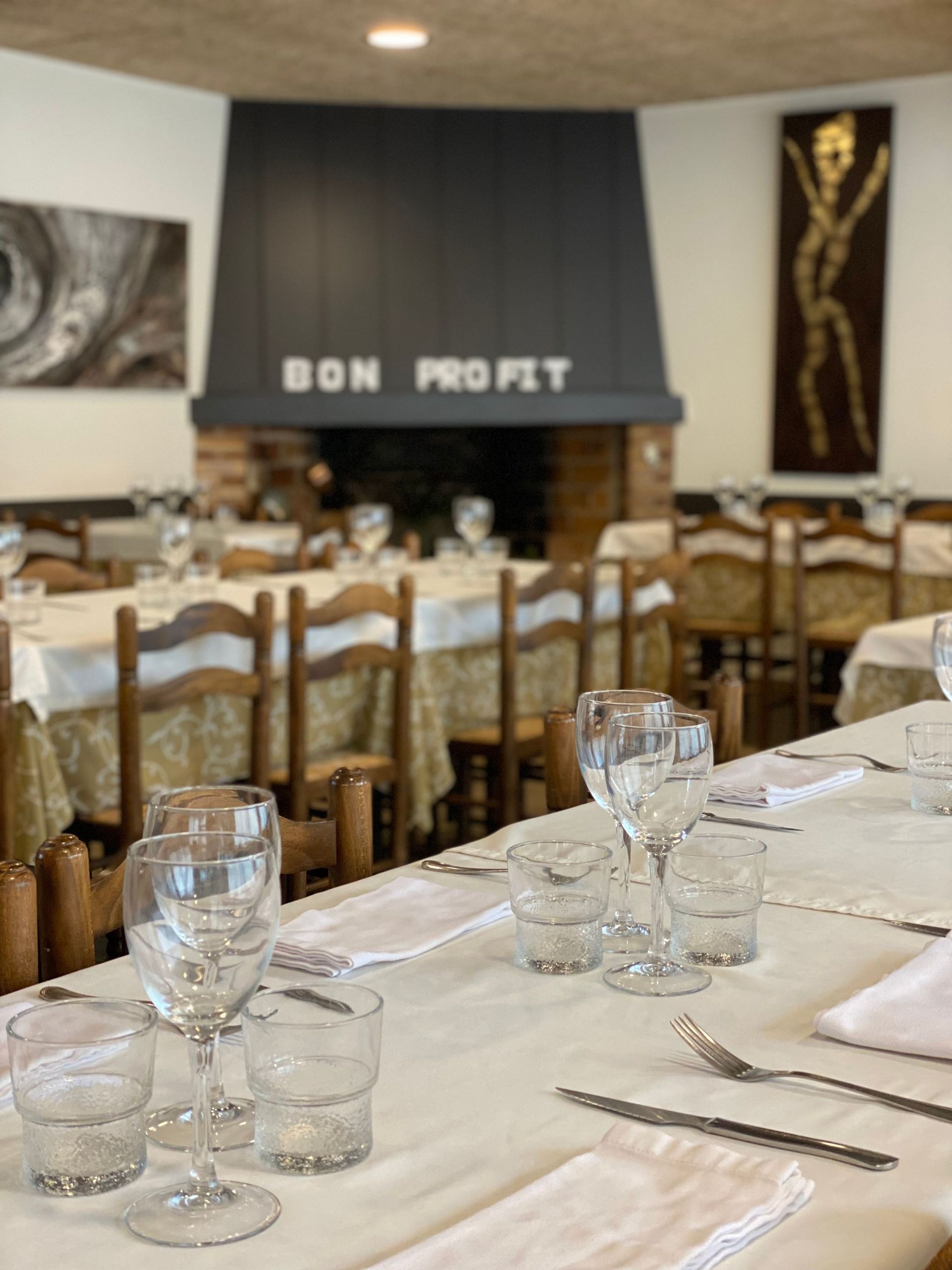 Un restaurant ple de taules, cadires i una llar de foc.