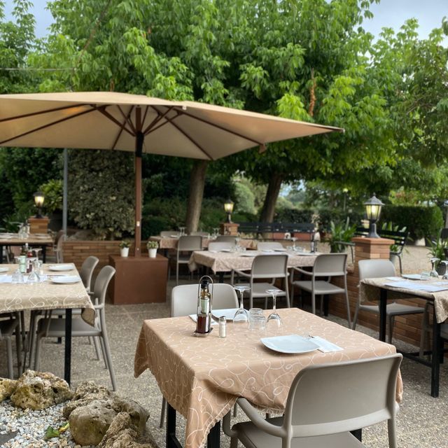 Un restaurant amb taules i cadires sota un para-sol