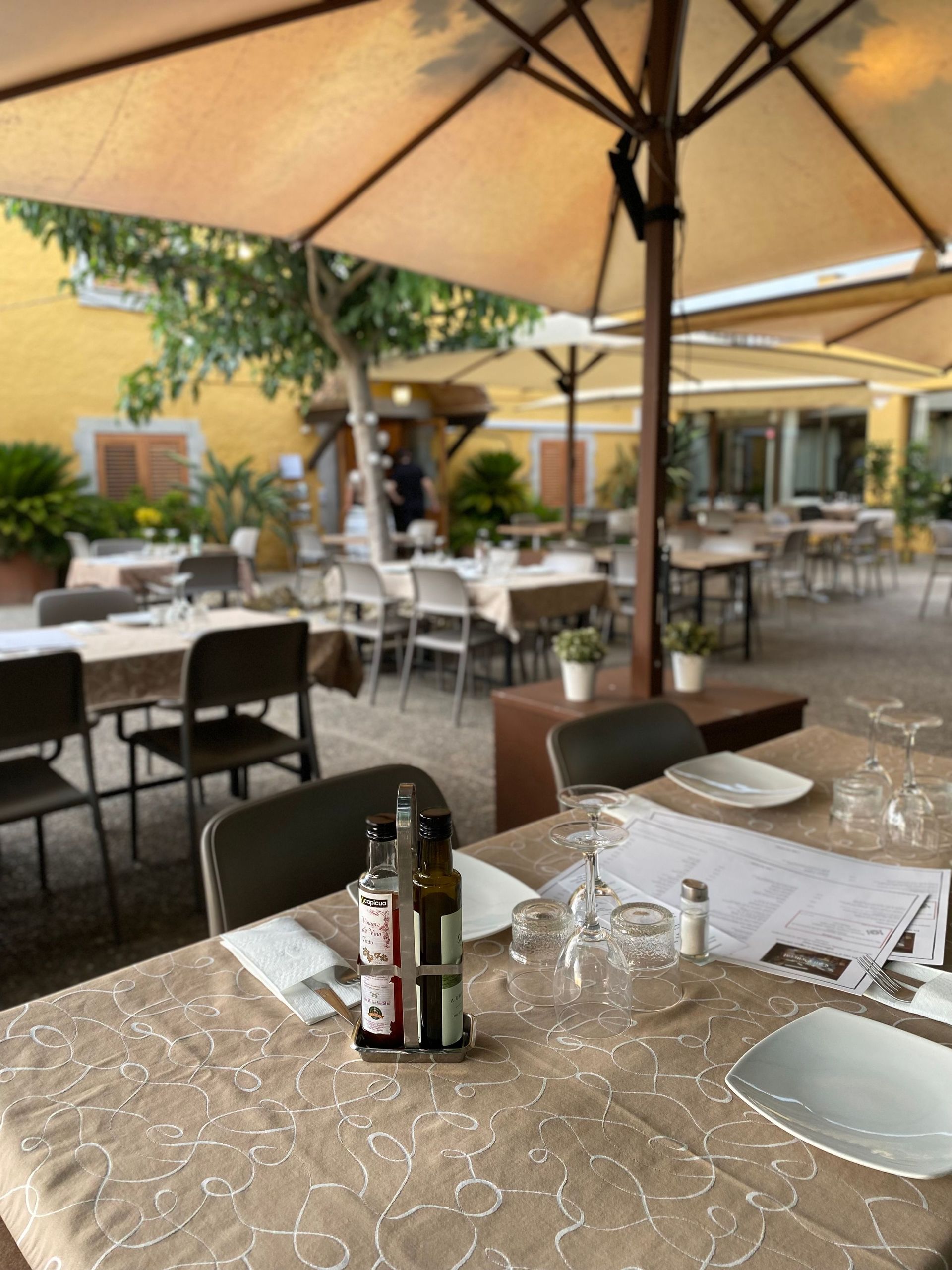 Un restaurant amb moltes taules, cadires i para-sols