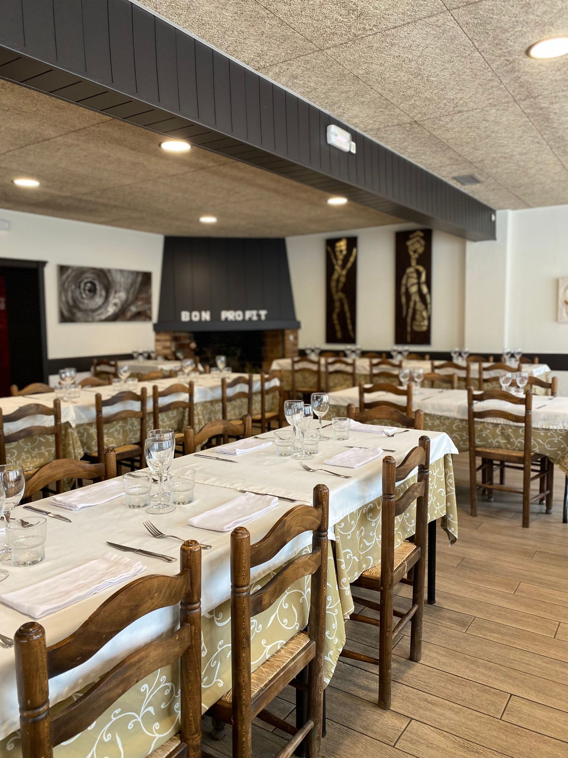 Un restaurant ple de taules, cadires i una llar de foc.