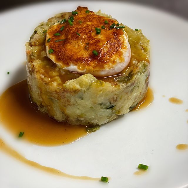 Un plat blanc amb puré de patates i salsa