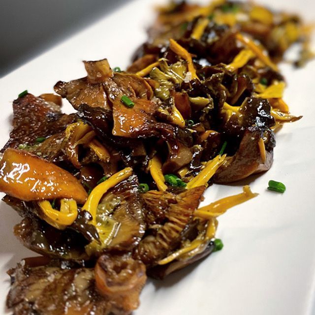 Un plat blanc cobert amb una varietat de verdures, com ara bolets i pastanagues