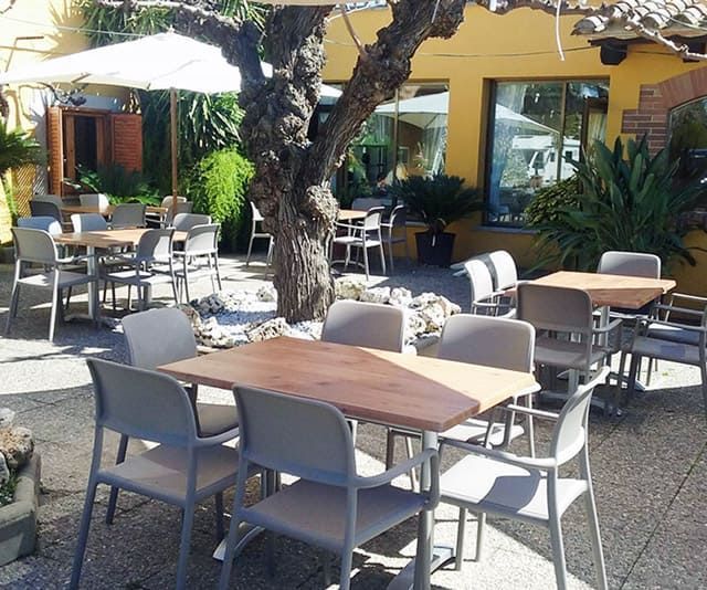 Taules i cadires a l'exterior d'un restaurant amb para-sols