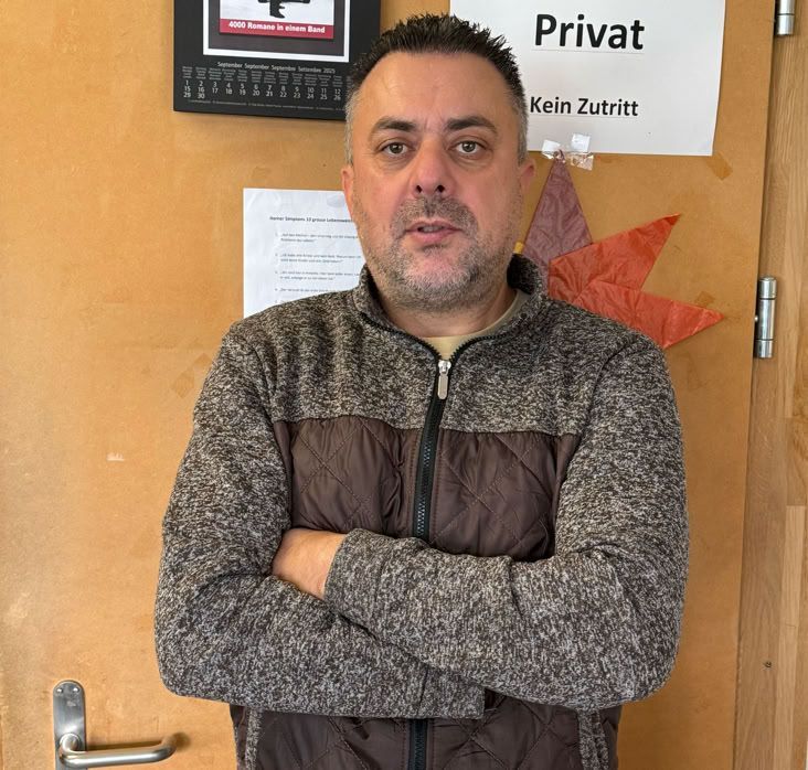 Empfangsbereich mit weiss-grünem Empfangstresen und Milchglastür.