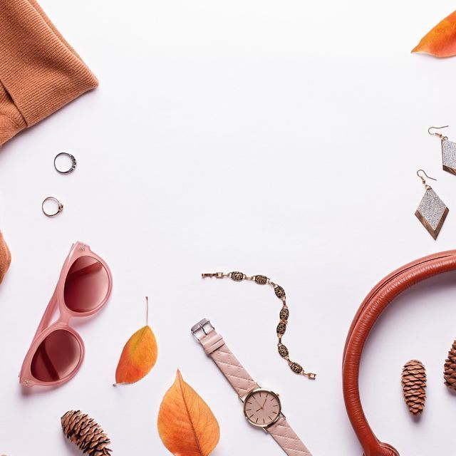 Un reloj y unas gafas de sol están sobre una superficie blanca.